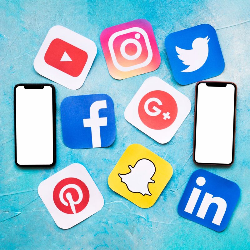 social-media-icons-with-two-blank-cellphone-blue-painted-wall (1)