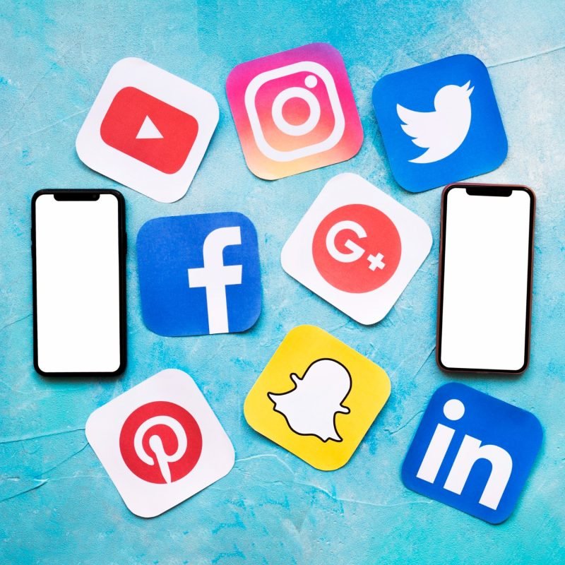 social-media-icons-with-two-blank-cellphone-blue-painted-wall (1)